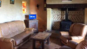 Una sala de estar acogedora con un sofá de cuero, una mesa de centro de madera y una chimenea.