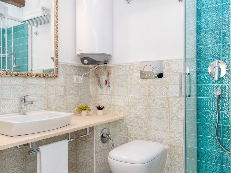 Un baño con lavamanos, inodoro y ducha.