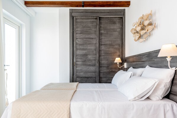 Un dormitorio con una cama grande, cabecera de madera, lámpara de pared y un adorno en la pared.