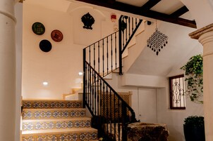 A staircase with ornate black railings and patterned tile steps.