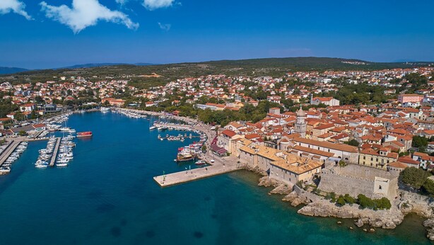 An aerial view of a coastal town with a marina, historic buildings, and a prominent church. - Villa LuiSole - Apartment °1 with heated saltwater pool, family-friendly (Krk)
