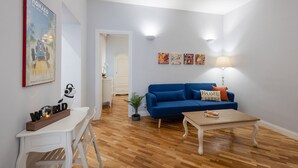 A living room with a blue sofa, a white table, and a lamp.