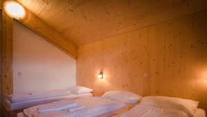 A wooden cabin room with two beds, each with neatly folded white linens and pillows. - 47# mit IR-Sauna& Sprudelbad Innen by Interhome (Turracher Höhe)