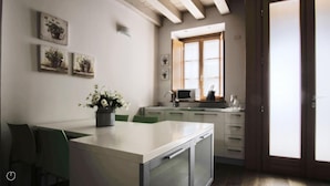 A modern kitchen with white cabinets, a built-in microwave, and a window above the sink.