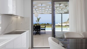 Una cocina moderna con vista a una piscina y zona de estar exterior.