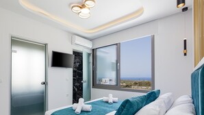 Una habitación de hotel moderna con cama, televisión, aire acondicionado y ventana con vistas al paisaje.