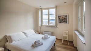 A bedroom with a bed, a window, a radiator, and a chair. - Virgilio 2 - Villa Bice (Alassio)