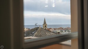 A view of a coastal town with a prominent church tower, a clear sky, and the sea in the background. - Virgilio 2 - Villa Bice (Alassio)