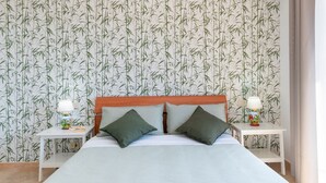 Une chambre d’hôtel avec un grand lit, deux tables de chevet et un papier peint à motifs de bambou.