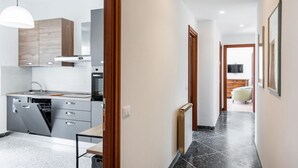 A modern kitchen with a dishwasher, oven, and wooden cabinets.