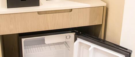 A compact refrigerator with a freezer compartment, a water dispenser, and a coffee maker.