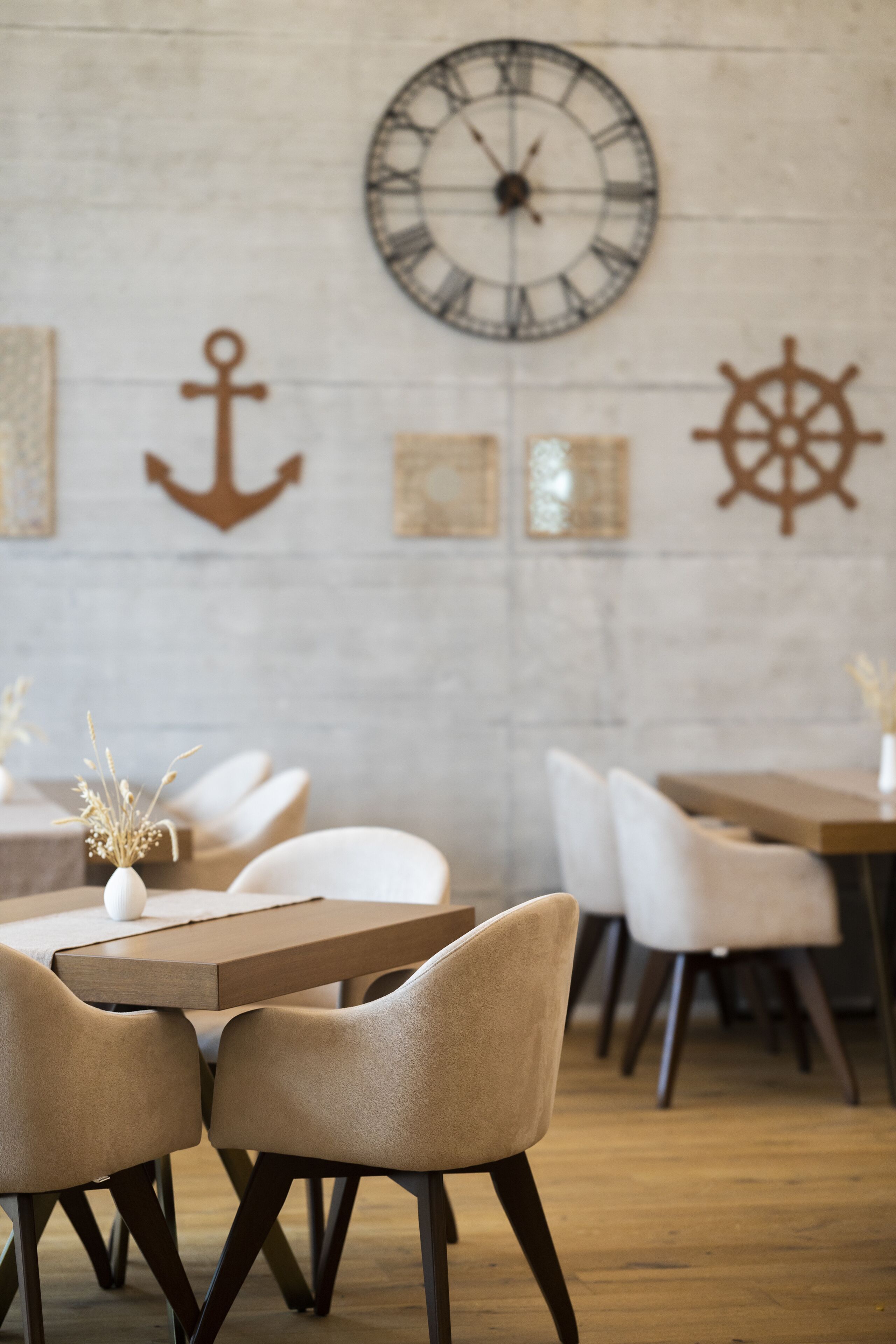 L’intérieur d’un restaurant, avec une grande horloge murale, des décorations sur le thème de la marine et des sièges modernes.