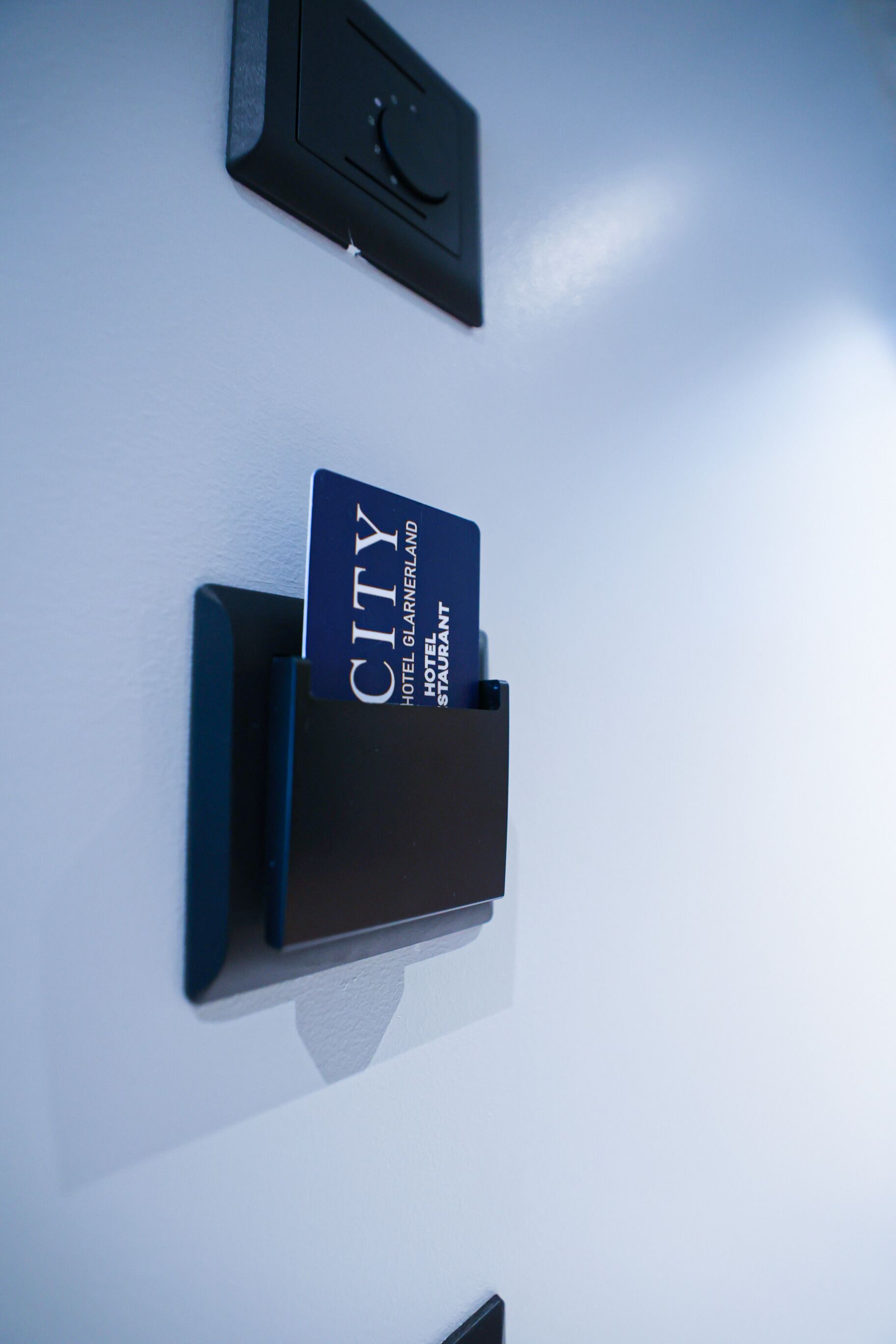 A hotel card reader with a card inserted, and a key card slot above it.