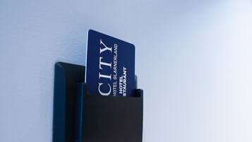 A hotel card reader with a card inserted, and a key card slot above it.