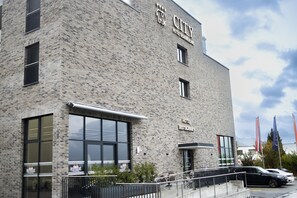 Un edificio de hotel con fachada de ladrillo, ventanas grandes y un cartel que indica que es un hotel y restaurante.