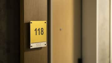 A yellow sign with the number 118 on a wooden door.