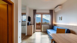 Et moderne hotelværelse med balkon, spiseplads og tekøkken.