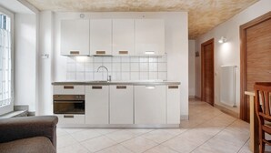 Une cuisine moderne avec des armoires blanches, un four encastré et un pare-feu en carreaux.