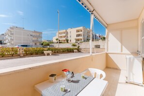 Un balcon équipé d’une table, de chaises, d’une bouilloire et d’une cafetière.