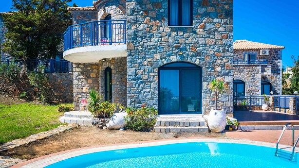 A stone building with a pool, a balcony, and a small garden. - Niriides Villas | Liagori | Villa 2-bedrooms with private pool (CHERSONISSOS-HERAKLION)