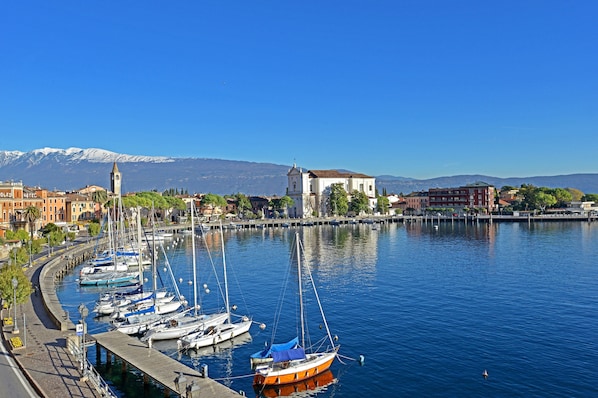 A marina with boats, a church, and mountains in the background.