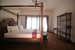 Restful retreat with a four-poster bed and wooden bookshelf.