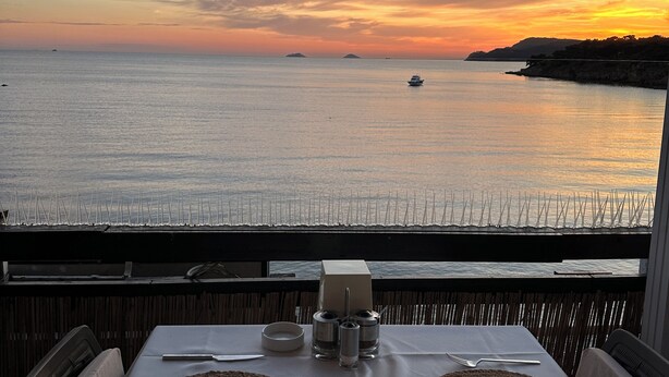 A table set for two with a view of the sea and a sunset. - Glamping Büyükada (Adalar)