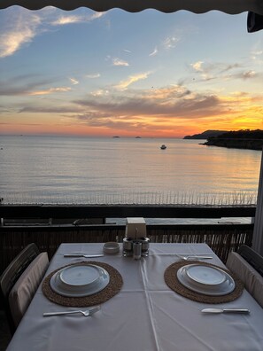 Mesa para dos con vista al mar y al atardecer.