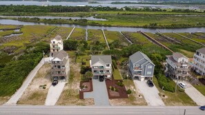 A coastal residential area with houses featuring balconies and waterfront views. - Enjoy oceanviews & Pool at Beyond the Sea, a spacious 4-bedroom home in North Topsail Beach. (North Topsail Beach)