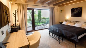Un dormitorio con cama, escritorio, silla y vistas al exterior.