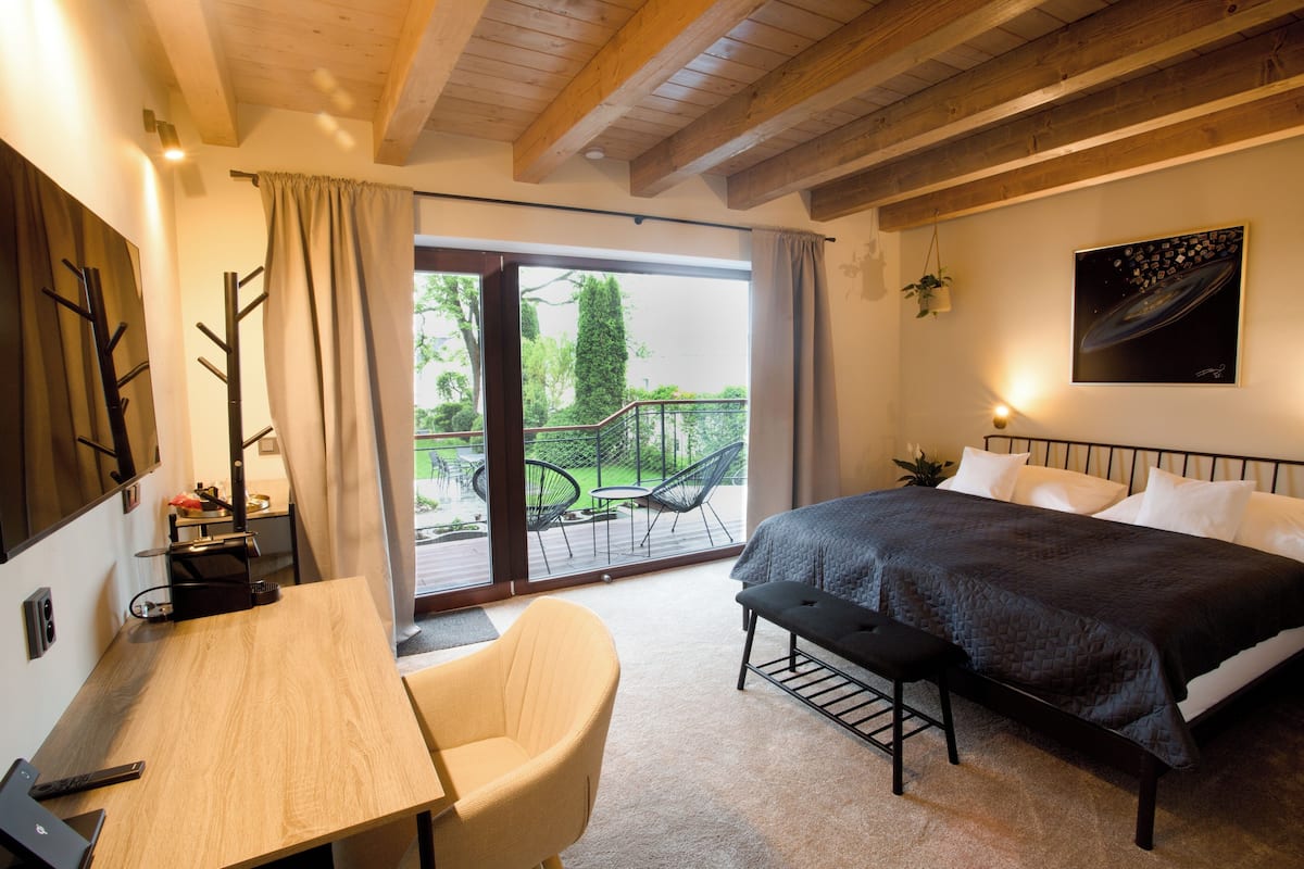 Una camera da letto con un letto, una scrivania, una sedia e vista sull'esterno.