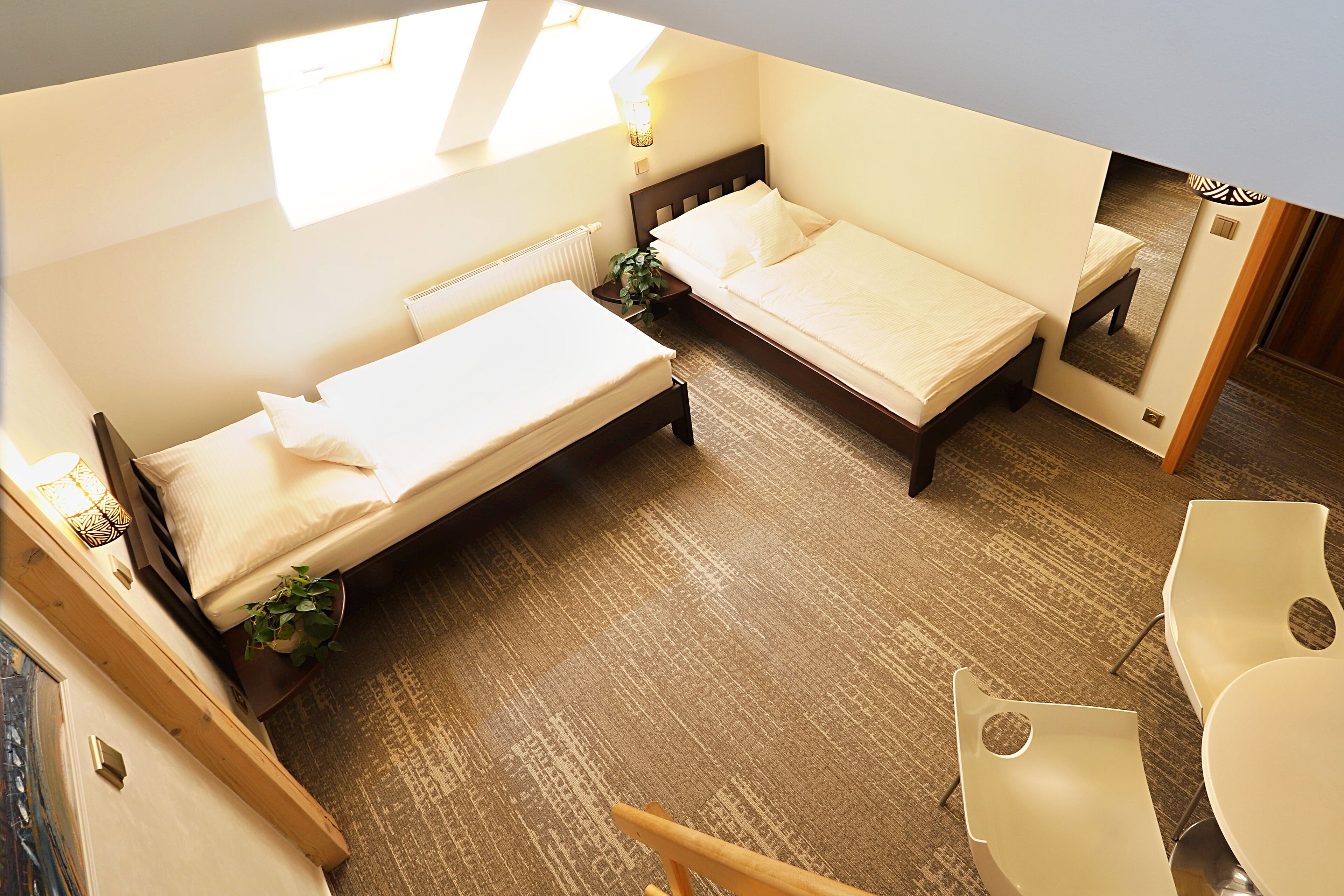 A hotel room with two beds, a desk, and a chair.