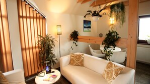 Una sala de estar moderna con un sofá, una mesa de centro y una planta en maceta.