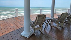A covered outdoor area with wooden deck, white columns, and beach views. - Boat House- Oceanfront Hot Tub! Creekfront, Dock & Pool (Pawleys Island)