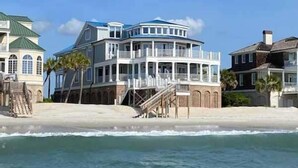 A beachfront property with a multi-level structure, a staircase leading to a balcony, and a view of the ocean. - Boat House- Oceanfront Hot Tub! Creekfront, Dock & Pool (Pawleys Island)