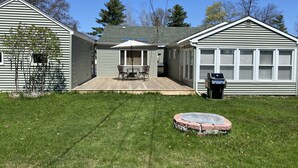 A two-story house with a patio, a barbecue grill, and a covered outdoor seating area. - Hidden gem, 2BR-2 Living, quiet neighborhood (Plattsburgh)