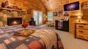 A cozy log cabin interior with a fireplace, a television, and a comfortable seating area. - American Spirit, Free Tickets, Hot Tub, WIFI, “Cozy Cabin Retreat in the Smokies (Sevierville)