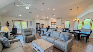A spacious living room with a sofa, coffee table, and dining area. - DUCK DUCHESS - Gorgeous, Spacious 5 BR home w/Private Pool and Rec Room (Duck)