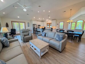 A spacious living room with a sofa, coffee table, and dining area.