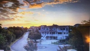 A residential street with houses, a driveway, and trees. - DUCK DUCHESS - Gorgeous, Spacious 5 BR home w/Private Pool and Rec Room (Duck)
