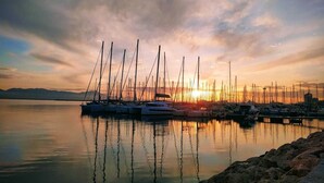 Eine Marina mit mehreren Segelbooten, die bei Sonnenuntergang vor Anker liegen.