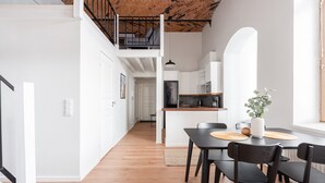 A modern kitchen with white cabinets, a black refrigerator, and a wooden countertop. - Stylish Historical Loft with Sauna & Free Parking (Tampere)