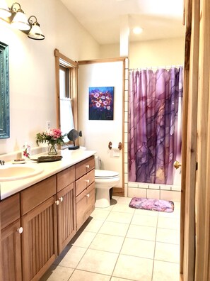 A bathroom with a wooden vanity, a sink, a toilet, and a shower curtain. - Heaven on Earth Nestled in the Blue Ridge Mountains (Vilas)