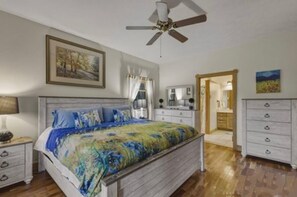 A bedroom with a bed, a ceiling fan, a dresser, and a door leading to another room. - Heaven on Earth Nestled in the Blue Ridge Mountains (Vilas)