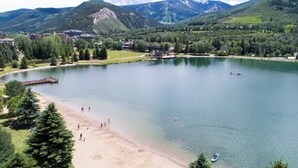 A lake with a dock, surrounded by mountains and a small town. - Prime Avon Location | Walk to Gondola & Dining | River Trail Access & Views (Avon)