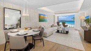 Un salon moderne avec un coin repas, une grande peinture et une vue sur la mer.