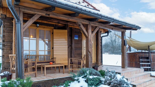 A wooden cabin with a covered porch, a bench, and a table. - Chalet Markoci With Hot Tub (Rakovica)
