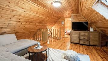Nhà gỗ dành cho gia đình, nhiều phòng ngủ, 2 phòng tắm, cạnh núi (Chalet Markoci With Hot Tub) | Khu phòng khách | TV 21-inch có truyền hình kỹ thuật số, lò sưởi, dàn stereo