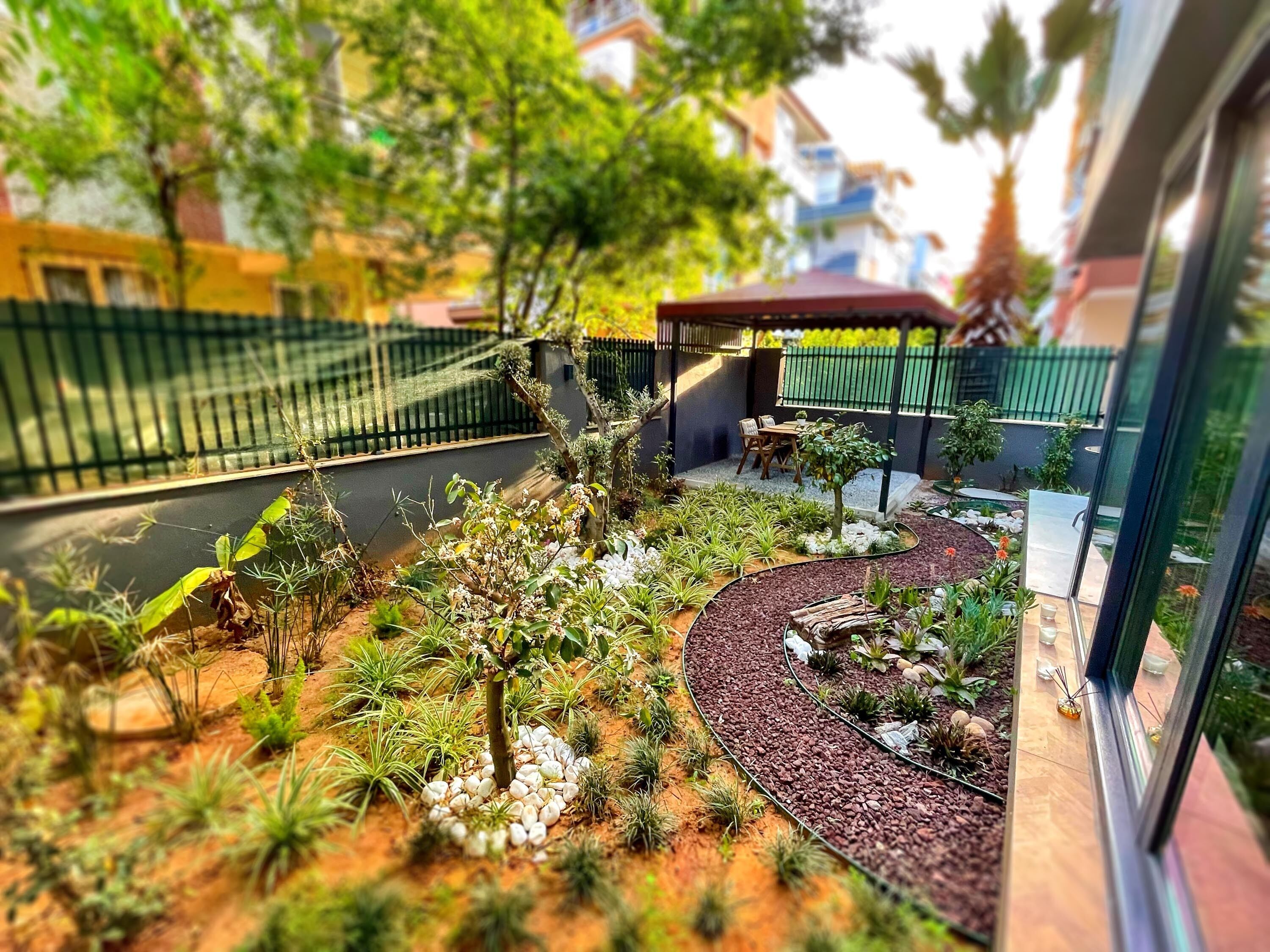 Ein angelegter Garten mit vielfältigen Pflanzen und einer Sitzgelegenheit.