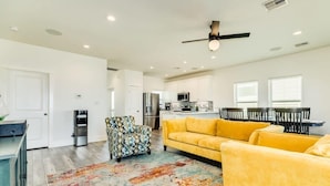 A modern kitchen with white cabinets, a stainless steel refrigerator, and a microwave. - Surfside's Casa Azul - Amazing Seaside Sunrise Spot! (Surfside Beach)